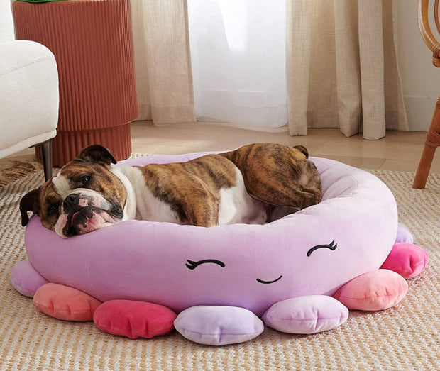 Pink donut-shaped novelty pet bed with a cozy interior.
