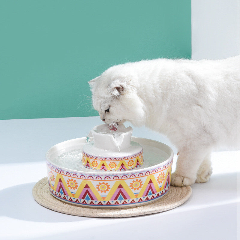 Automatic ceramic water feeder for pets with a colorful basin design, featuring a silent pump for smooth flow, shown in use by a white cat.